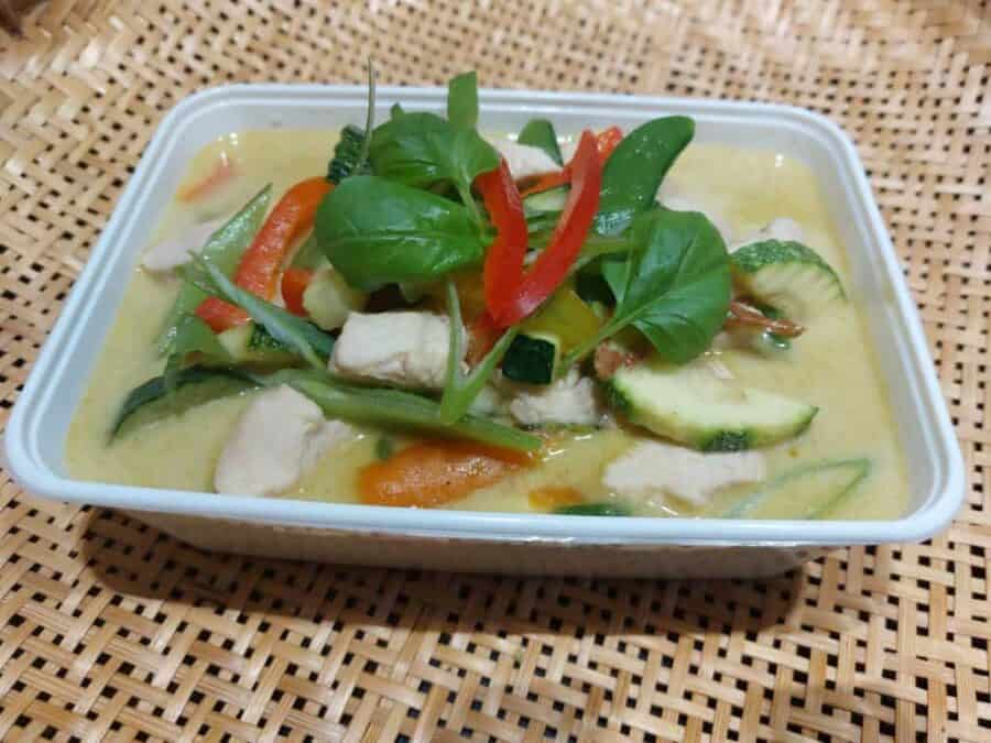 Verse curry met groenten en kip in een witte schaal.