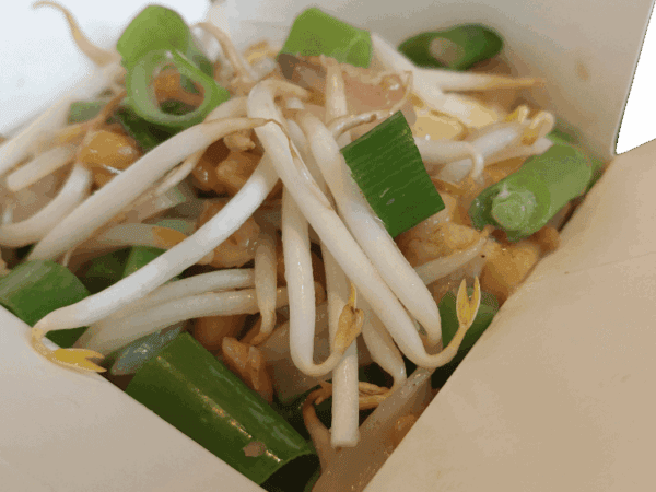 Verse Aziatische noedelmaaltijd met groenten en taugé in een take-away doos.