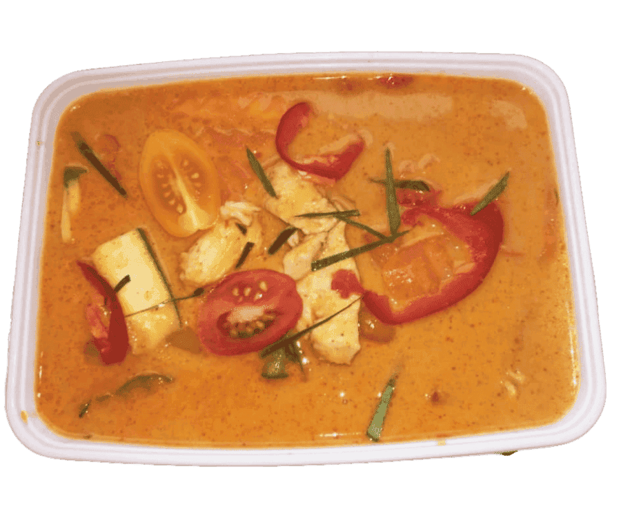 Thaise curry met groenten en tomaten in een witte schaal.