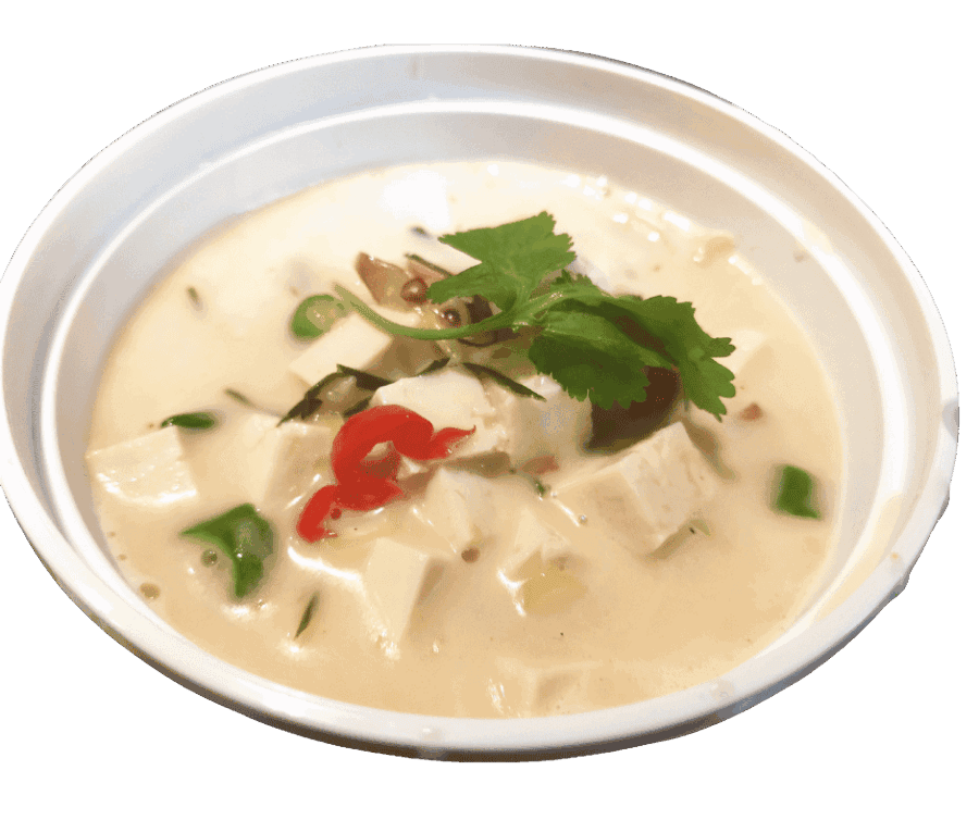 Authentieke Thaise Tom Kha Kai kokossoep met kip en verse kruiden.