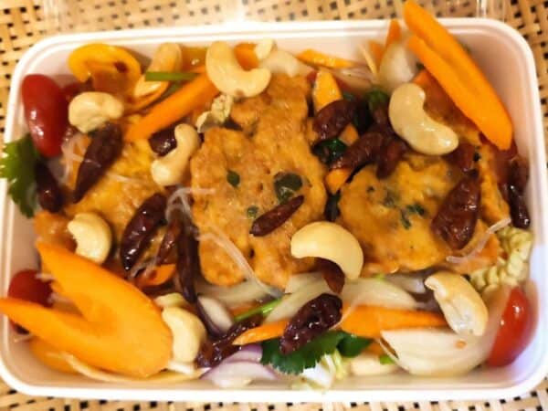 Verse Thaise kip met groenten, cashewnoten en pittige saus in een take-away bak.