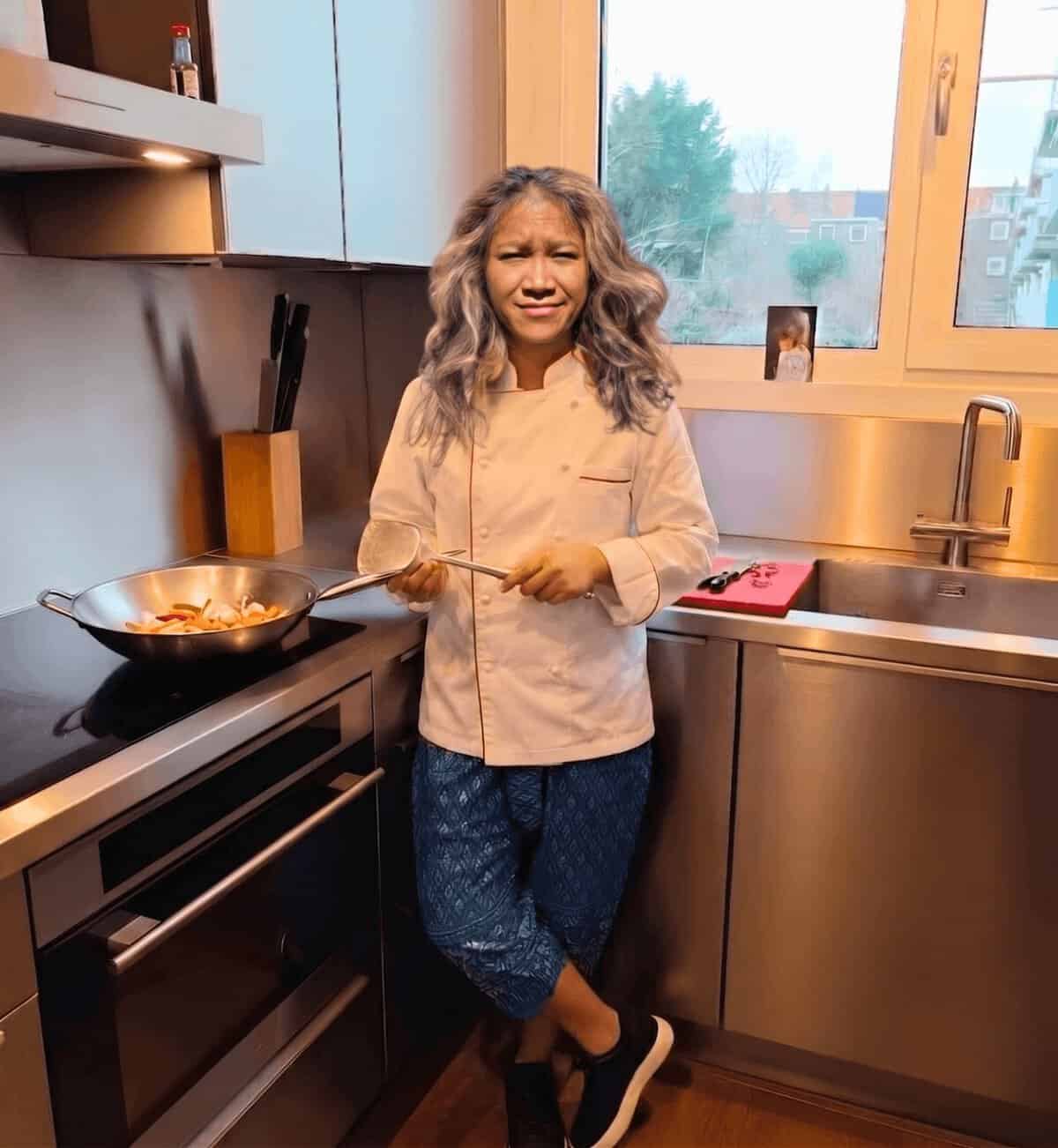 Pornshita van Siam Kitchen kookt Thais eten in de wok in haar keuken in Rotterdam Overschie